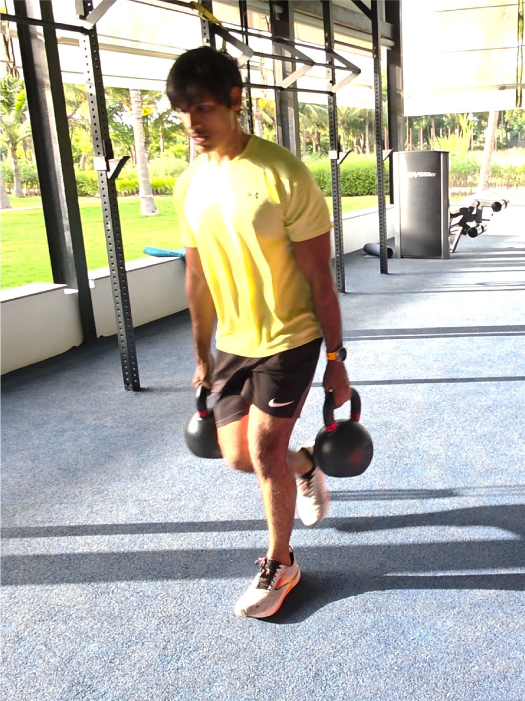 Guest walking with kettlebells post workout at Sol Fitness